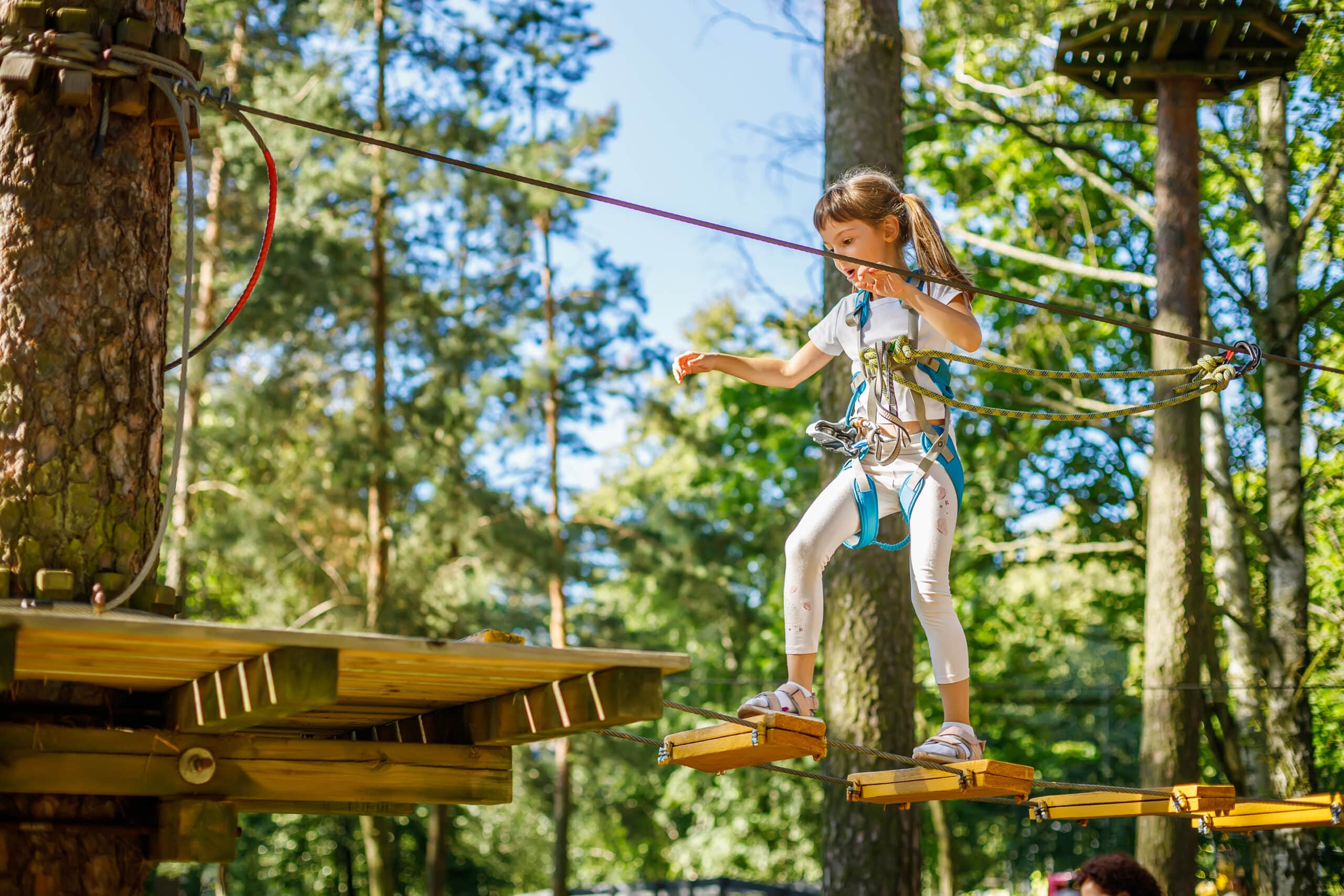Family-friendly summer activity near Chillouthouse in Idre Himmelfjäll – girl on a high ropes course in the forest